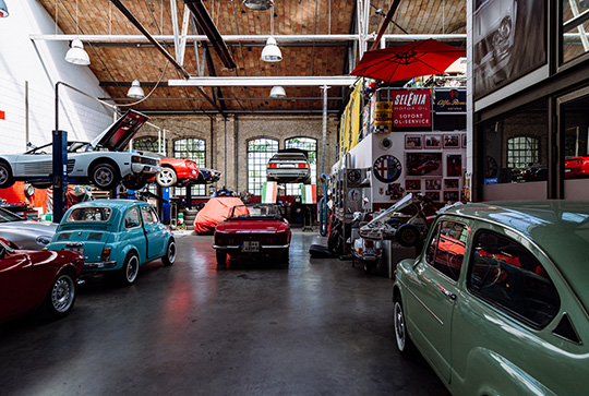 A garage with many cars parked on the floor.